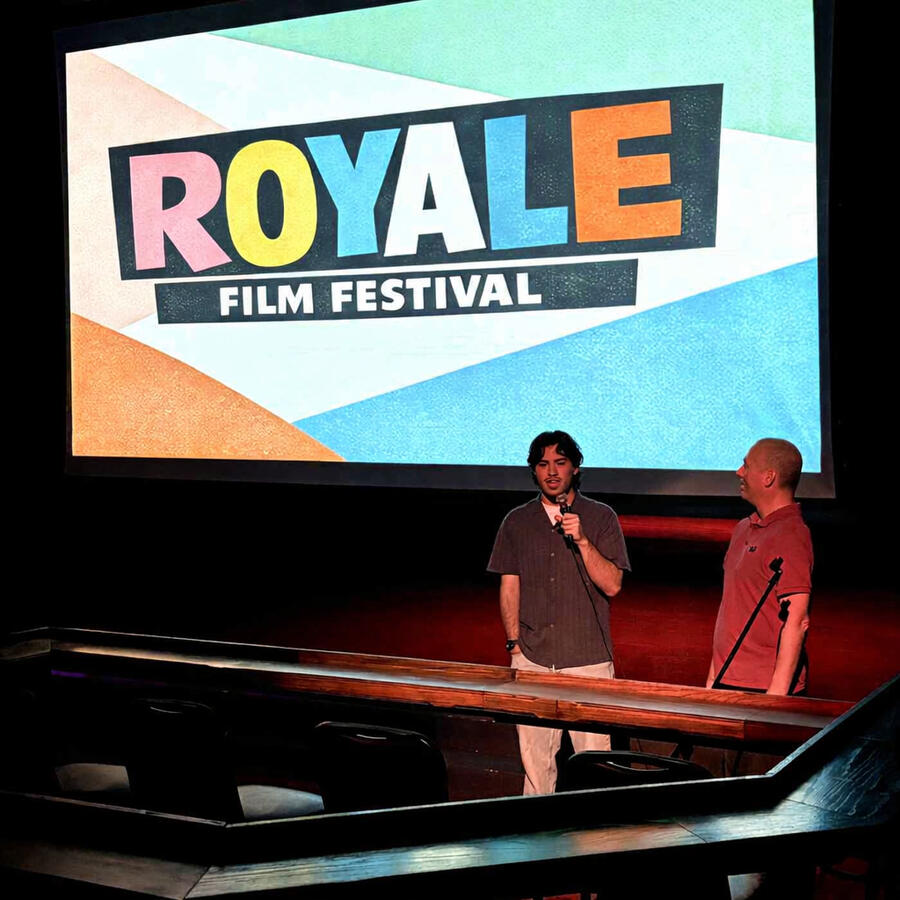 Sierra Vista filmmaker Evan Escue (left) introduces his short film, In Another Life, with a Q&A on Day 2 of the 3rd annual Royale Film Festival, with host Danny Hercules. (Photo by Yvette Ponte. Enhanced by Cherry.)