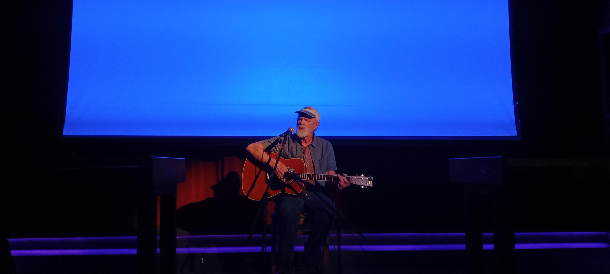 Local filmmaker Bruce Endres performs live before a screening of his music documentary Wall of Dreams